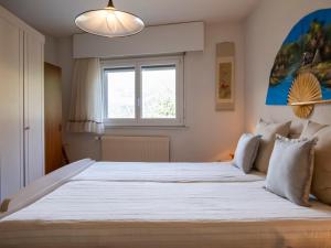Schlafzimmer mit einem großen weißen Bett und einem Fenster in der Unterkunft Apartment Les Girolles A59 by Interhome in Verbier