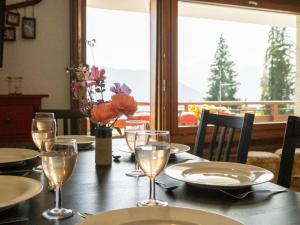 einen Tisch mit Tellern und Gläsern mit Aussicht in der Unterkunft Apartment Atlantic 112 by Interhome in Verbier