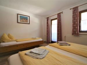 1 Schlafzimmer mit 2 Betten und 2 Fenstern in der Unterkunft Holiday Home Hauser by Interhome in Mayrhofen
