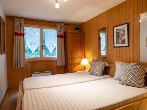 1 dormitorio con 2 camas y 2 ventanas en Apartment Baudrier A04 by Interhome, en Verbier