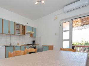 eine Küche mit einem Tisch und Stühlen sowie einem Fenster in der Unterkunft Holiday Home Ines by Interhome in Kali