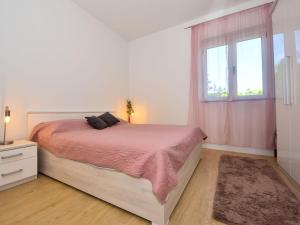 ein weißes Schlafzimmer mit einem Bett und einem Fenster in der Unterkunft Holiday Home Ines by Interhome in Kali