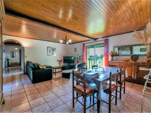 a living room with a wooden ceiling and a table and chairs at Holiday Home Le Coustal - BSB300 by Interhome in Blanquefort-sur-Briolance