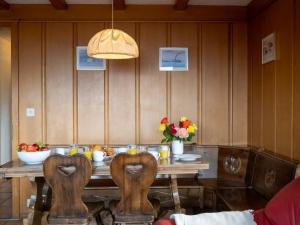 une table en bois avec des chaises et des fleurs. dans l'établissement Apartment Pierreval 18 by Interhome, à Verbier