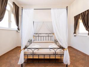- une chambre avec un lit à baldaquin et des rideaux dans l'établissement Apartment Winery Villa Vitas Dépendance - App-2 by Interhome, à Strassoldo