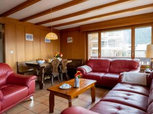 - un salon avec des canapés rouges et une table dans l'établissement Apartment Pierreval 18 by Interhome, à Verbier