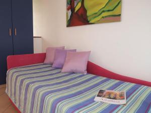 a bed with a colorful blanket and a book on it at Apartment Adalgisa - LBN128 by Interhome in Labin