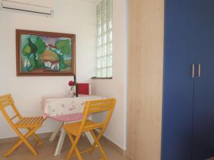 a table and chairs in a room with a painting at Apartment Adalgisa - LBN128 by Interhome in Labin