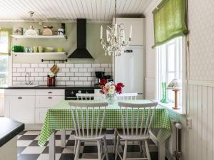 eine Küche mit einem Tisch mit einem grünen und weißen Tischtuch in der Unterkunft Chalet Långban - VMD233 by Interhome in Filipstad