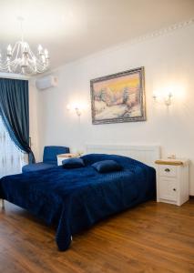 um quarto com uma cama azul e um lustre em RELAX COMPLEX HOTEL em Boryspil