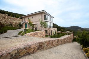 ein Haus auf einem Hügel mit einer Steinmauer in der Unterkunft Marlo Ayvalık 12 Plus Adult Only in Ayvalık + 138 Fotos