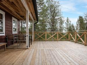 een houten terras met een tafel en stoelen op een huis bij Chalet Lofsdalen Lavskrikan by Interhome in Lofsdalen