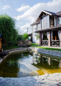 uma casa com um lago em frente a uma casa em RELAX COMPLEX HOTEL em Boryspil