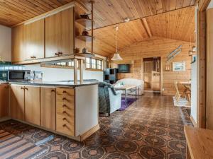 a kitchen and living room in a log cabin at Chalet Lofsdalen Lavskrikan - HJD030 by Interhome in Lofsdalen