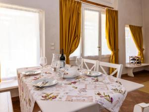 mesa de comedor con mantel blanco y copas de vino en Apartment Winery Villa Vitas Dépendance - App-1 by Interhome, en Strassoldo