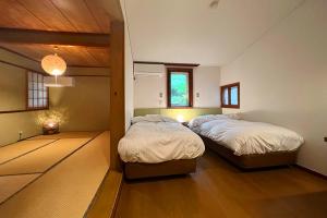 山中湖的住宿－Windy hill 森の宿，铺有木地板的客房内的两张床