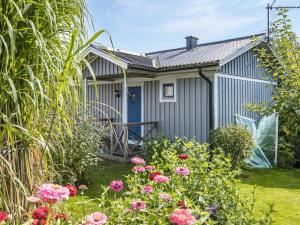 une maison avec une porte bleue et quelques fleurs dans l'établissement Holiday Home Täppan - SKO184 by Interhome, à Bromölla