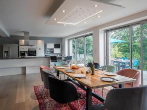Il comprend une cuisine et une salle à manger avec une table et des chaises en bois. dans l'établissement Villa La Boissière - MLX200 by Interhome, à Morlaix
