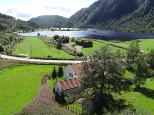 a house in a field next to a lake at Holiday Home Olavbu - SOW105 by Interhome in Åseral