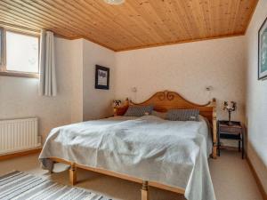 - une chambre avec un grand lit et un plafond en bois dans l'établissement Chalet Korpstigen Renen - DAN074 by Interhome, à Sälen