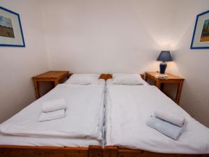two twin beds in a room with two tables at Apartment Nordseestern by Interhome in Norddeich