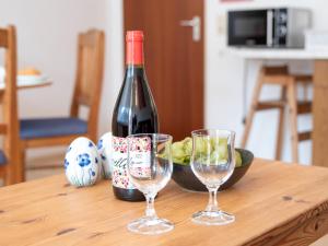 a bottle of wine and two glasses on a table at Apartment Nordseestern by Interhome in Norddeich