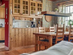 a kitchen with wooden cabinets and a wooden table and chairs at Chalet Lofsdalen Furan by Interhome in Lofsdalen