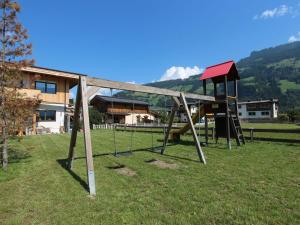 einen Park mit einer Schaukel im Gras in der Unterkunft Holiday Home Schwendau-2 by Interhome in Hippach