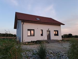 ein kleines weißes Haus mit rotem Dach in der Unterkunft Honey House in Gęsiniec