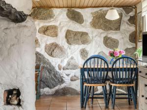a dining room with two chairs and a stone wall at Holiday Home Västra Näs - B in Sölvesborg
