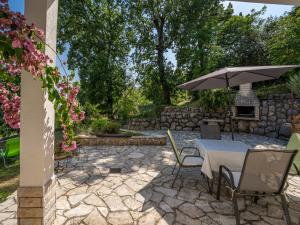 a patio with a table and an umbrella at Apartment Emil by Interhome in Lovran