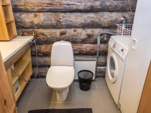a bathroom with a toilet and a washing machine at Holiday Home Rukakämmekkä by Interhome in Ruka