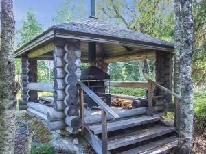 a log cabin with a grill in the woods at Holiday Home Lomamaja rukaranta by Interhome in Ruka