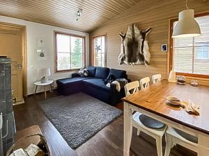 a living room with a blue couch and a table at Holiday Home Länsirinne c 12 by Interhome in Ruka