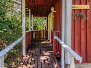 eine Veranda eines roten Hauses mit einem hölzernen Gehweg in der Unterkunft Holiday Home Rantasipi 1 by Interhome in Strandby