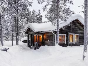 una cabaña de madera en la nieve en Holiday Home Villemi by Interhome, en Saariselkä