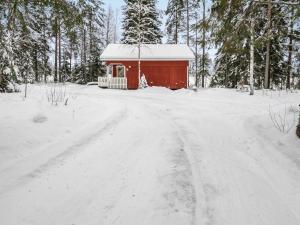 JuhanalaにあるHoliday Home Rajala by Interhomeの赤い小さな建物の隣の雪道