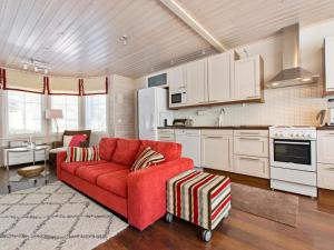 een woonkamer met een rode bank en een keuken bij Holiday Home Vuosselinhovi a by Interhome in Ruka