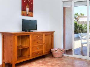 Les tres CalesにあるHoliday Home Villa Santa Marta I by Interhomeのリビングルームの木製ドレッサーのテレビ