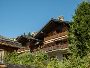 un gran edificio con balcones de madera y árboles en Apartment Licorne by Interhome, en Verbier