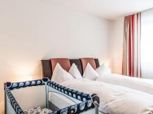 エンゲルベルクにあるApartment TITLIS Resort 3-Zimmer Familienwohnung 3 by Interhomeのベッドルーム1室(ベッド2台、窓付)