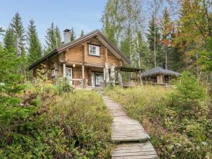 a wooden path leading to a log cabin at Holiday Home Pikku harrila by Interhome in Huuhanaho +21 photos
