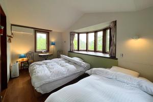 山中湖的住宿－Windy hill 森の宿，一间卧室设有两张床和窗户。