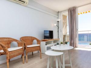 sala de estar con mesa, sillas y TV en Apartment Clipper by Interhome, en Sant Vicenç de Montalt