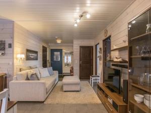 ein Wohnzimmer mit einem Sofa und einem TV in einem Zimmer in der Unterkunft Holiday Home Hil-lak-ka ii as 7 by Interhome in Äkäslompolo