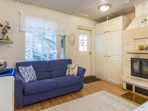 ein blaues Sofa im Wohnzimmer mit Kamin in der Unterkunft Holiday Home Rajala by Interhome in Neuvosenniemi