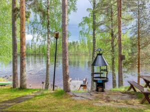 een picknicktafel en een vogelvoeder naast een meer bij Holiday Home Aurinkoranta by Interhome in Hattusaari