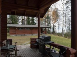 een afgeschermde veranda met een grill en een blokhut bij Holiday Home Raatiannokka by Interhome in Ikaalinen