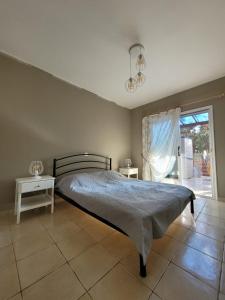 a bedroom with a bed and a table and a window at Limnaria Gardens Paphos, near beach in Paphos