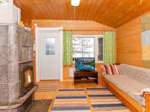 ein Wohnzimmer mit einem Kamin und einem Sofa in der Unterkunft Holiday Home Maunonlahti by Interhome in Hattusaari